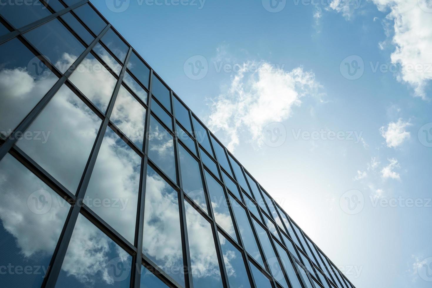 edificio alto de varios pisos con ventanas espejadas contra el cielo. arquitectura urbana moderna. foto