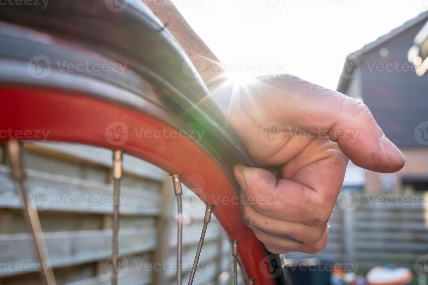 Cyclist manually removes a tire from a punctured bicycle wheel. Bike repair. photo