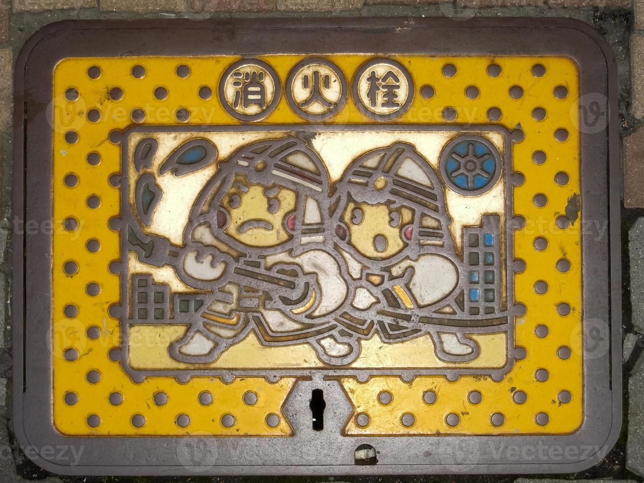Japanese Sewer Grate depecting firefighters in Tokyo Japan photo