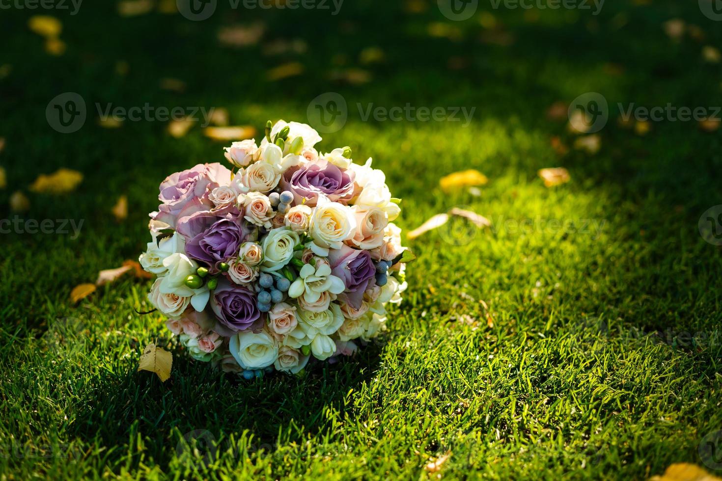 Delicate wedding bouquet lies on a background of green grass photo