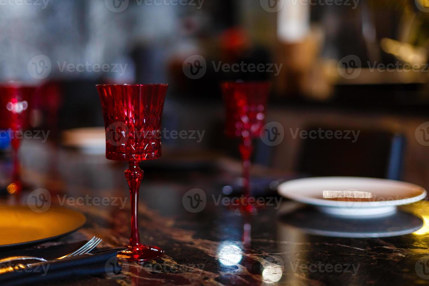 Glasses, forks, knives, plates on a table in restaurant served for dinner photo