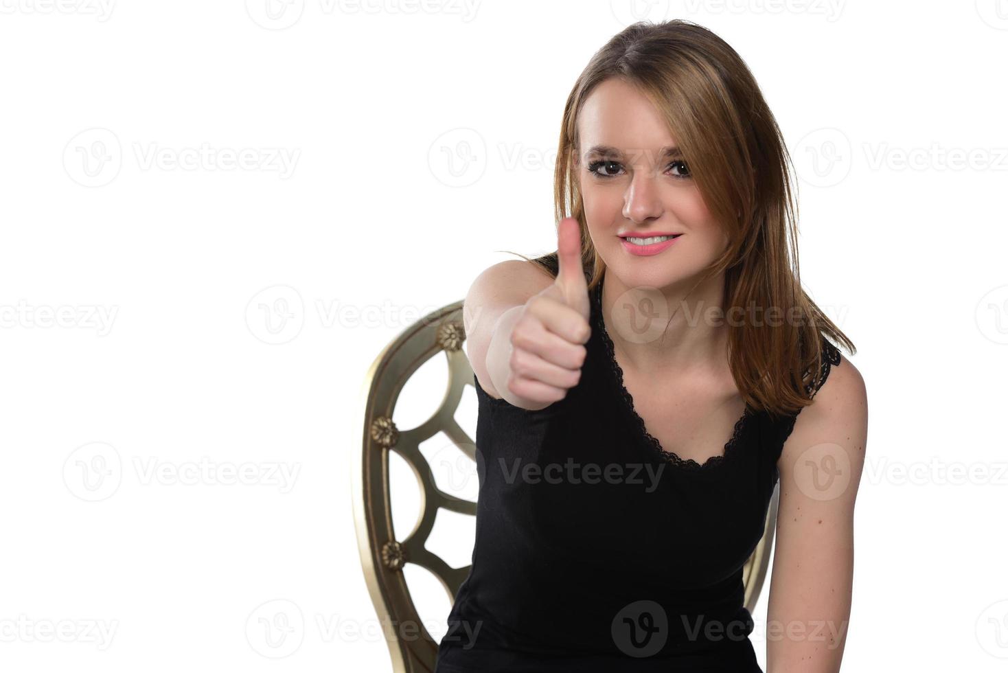 retrato de una joven hermosa mujer mirando a la cámara mostrando los pulgares hacia arriba. aislado en blanco foto