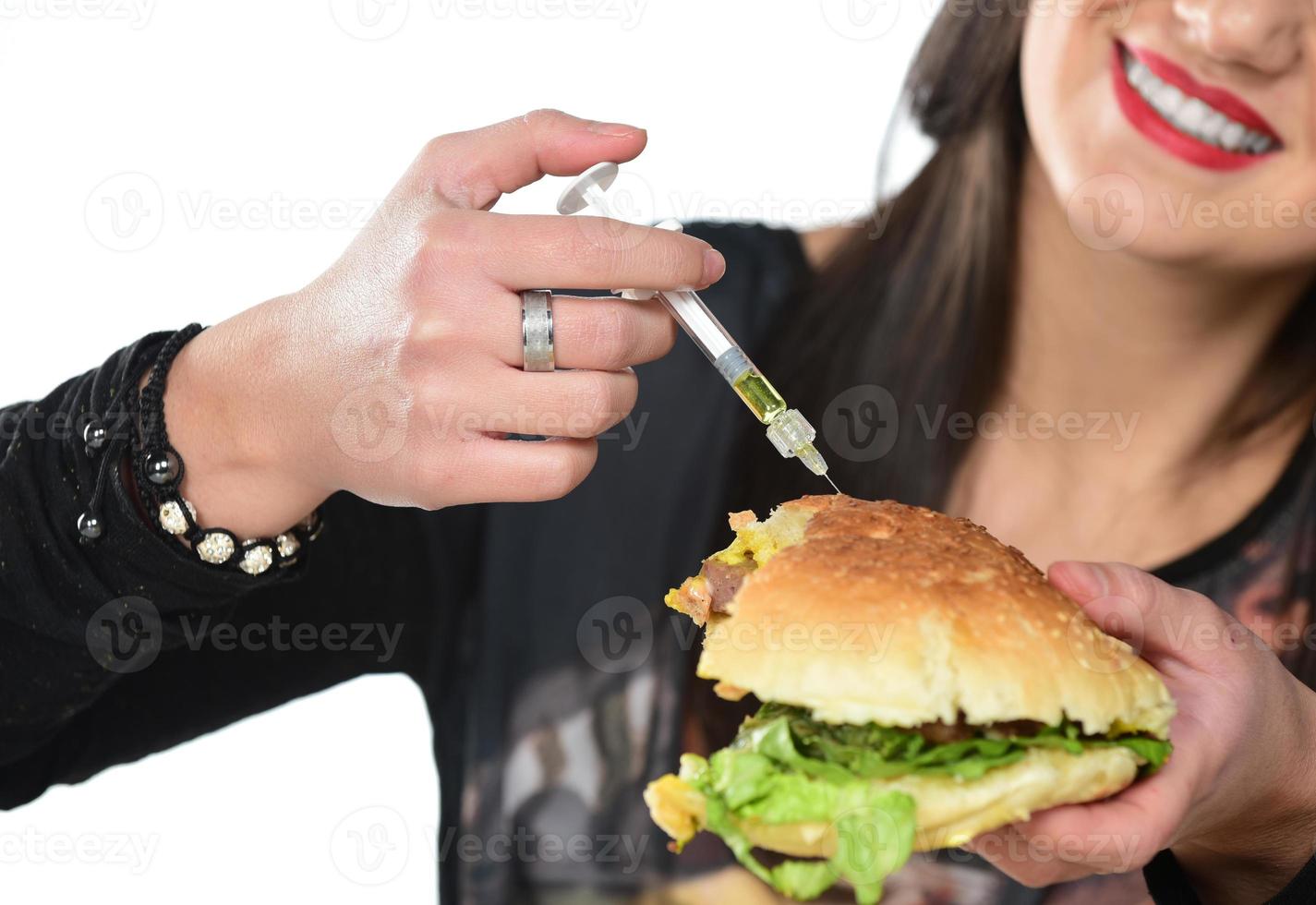 Beautiful woman inject cholesterol in side of hamburger sandwich photo