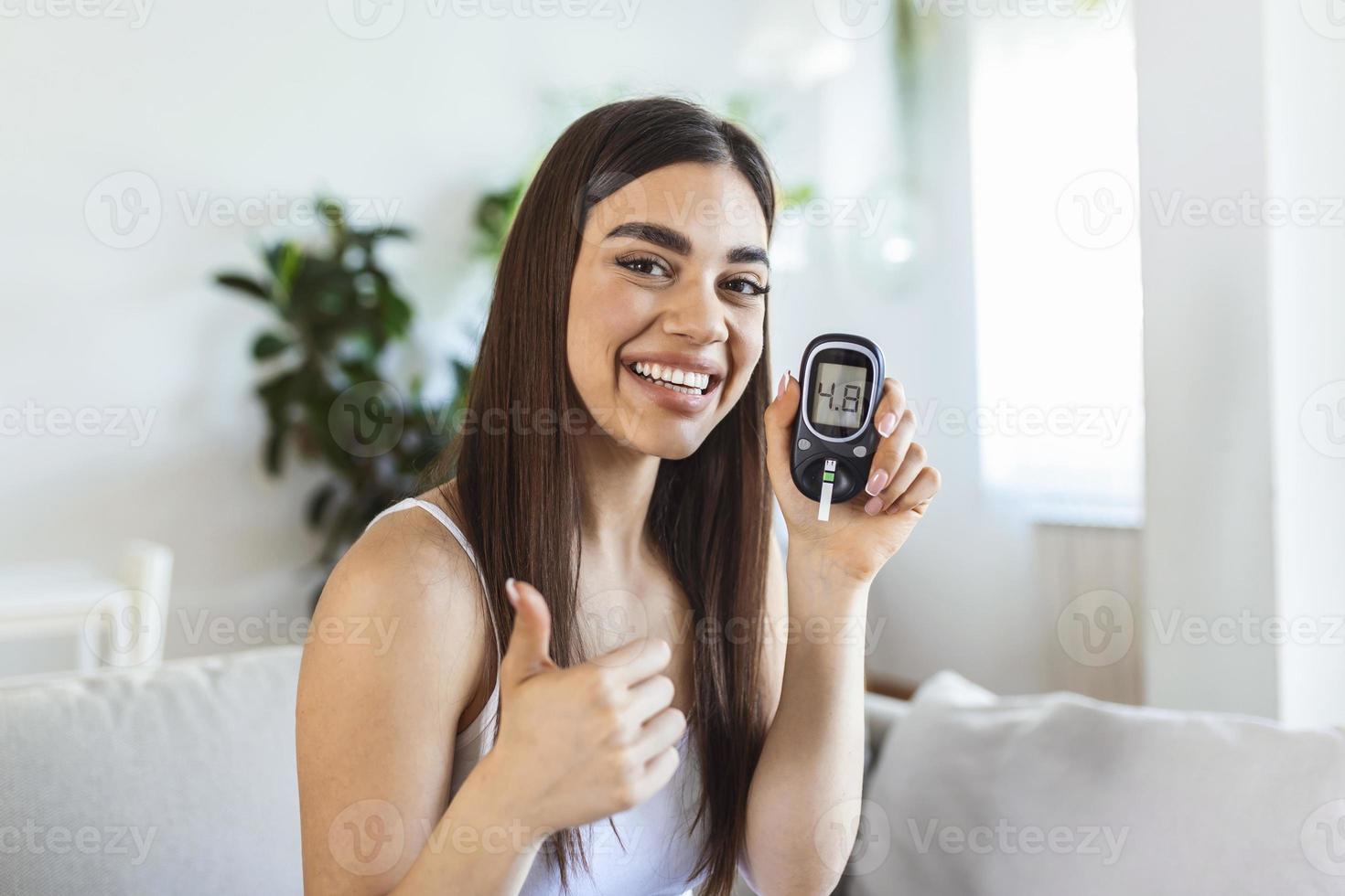 Blood sugar testing at home. Checking Blood Sugar Level At Home. Diabetic Checking Blood Sugar Levels. Woman checking blood sugar level by glucometer and test stripe at home photo