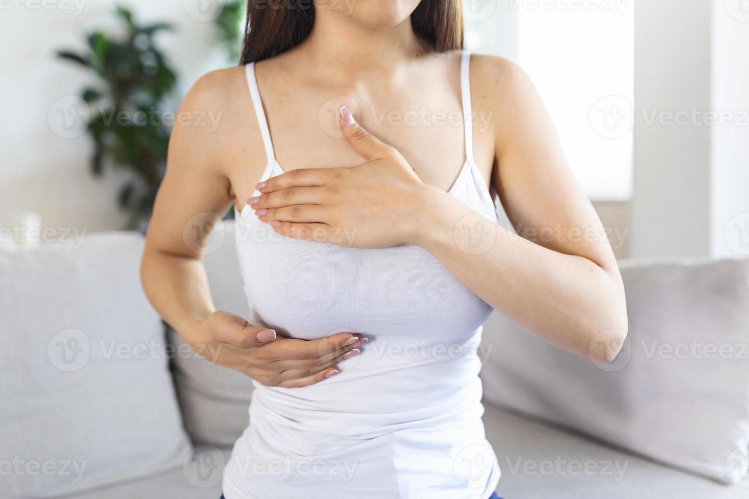 Young caucasian woman palpating her breast by herself that she concern about breast cancer. Healthcare and breast cancer concept photo