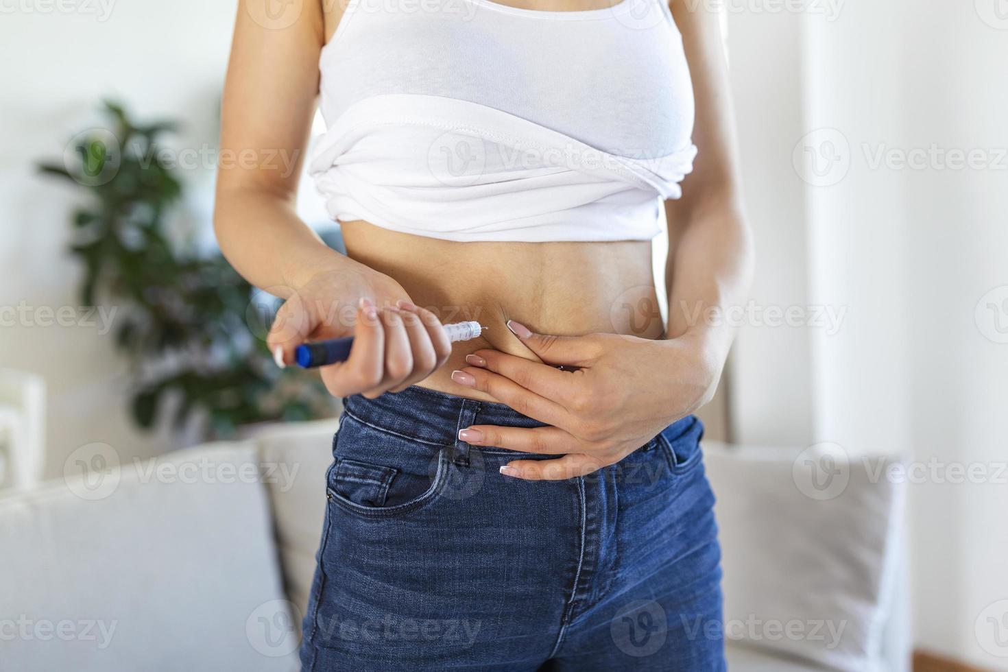 A diabetic patient using insulin pen for making an insulin injection at home. Young woman control diabetes. Diabetic lifestyle photo