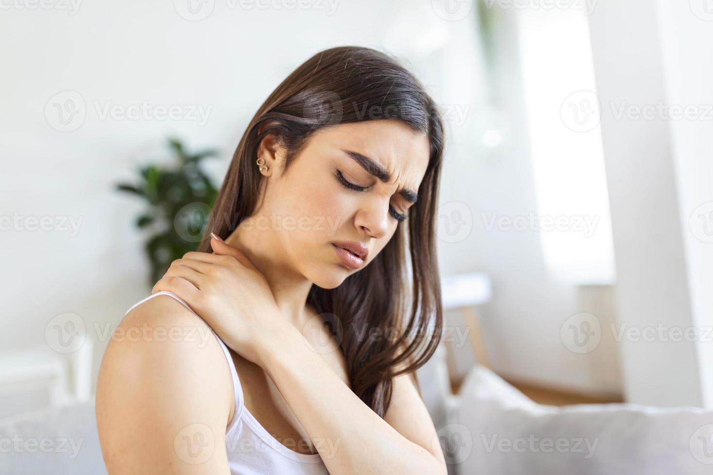 Tired woman massaging stiff sore neck, tensed muscles fatigued from computer work in incorrect posture while feeling hurt joint shoulder back pain ache. Fibromyalgia concept photo