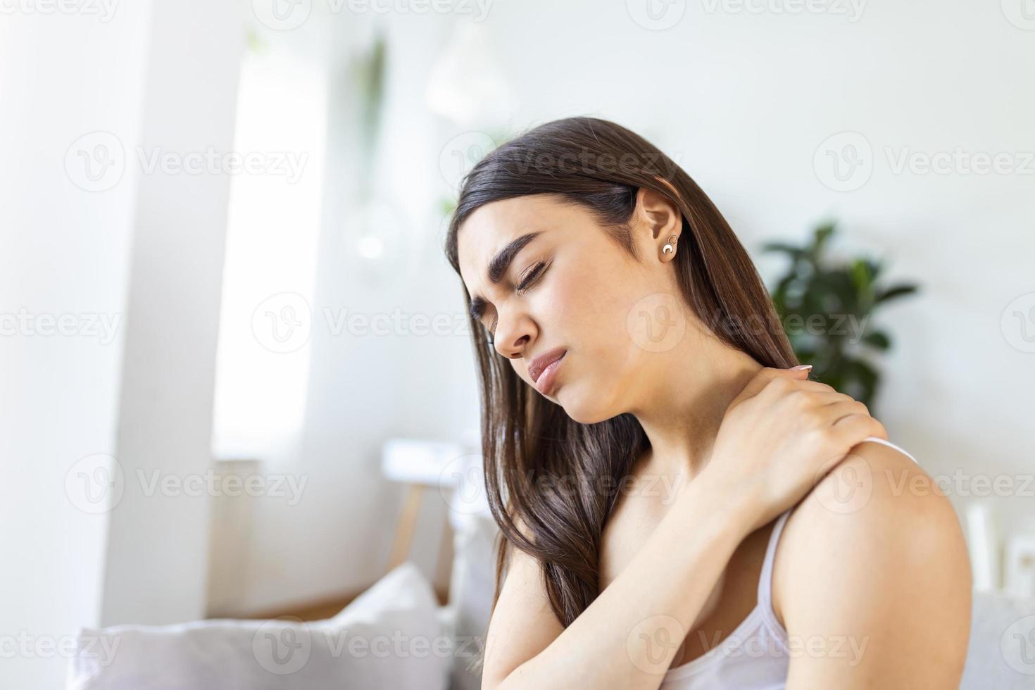 Tired woman massaging stiff sore neck, tensed muscles fatigued from computer work in incorrect posture while feeling hurt joint shoulder back pain ache. Fibromyalgia concept photo