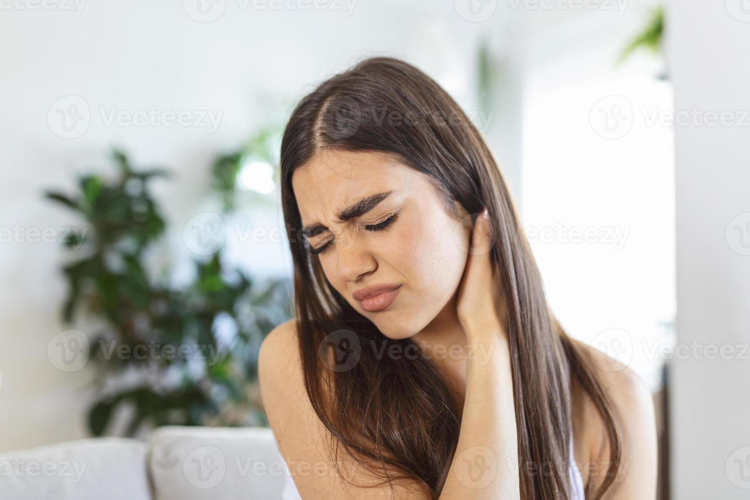 mujer cansada masajeando el cuello rígido y dolorido, músculos tensos fatigados por el trabajo de la computadora en una postura incorrecta mientras siente dolor en las articulaciones del hombro dolor de espalda. concepto de fibromialgia foto