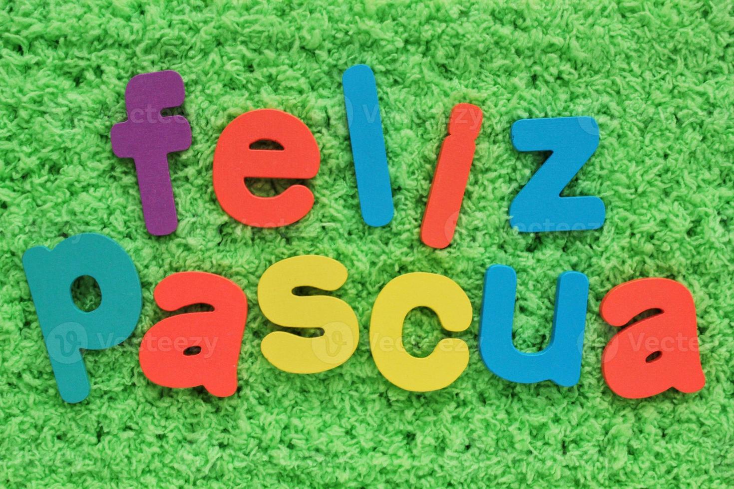 Feliz Pascua, Happy Easter on spanish colored lettering on green grass background. Holiday spring compostion concept. Creative idea for greeting card, poster, banner, invitation. Top view, flat lay photo