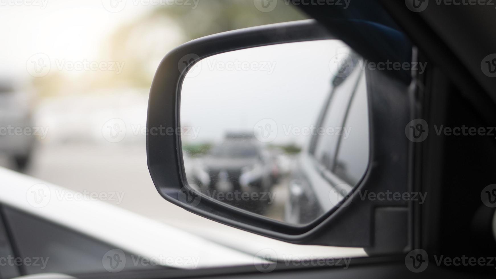 Perspective view of mirror wing of car in the parking area. with blurred of other car reflection in the mirror. photo