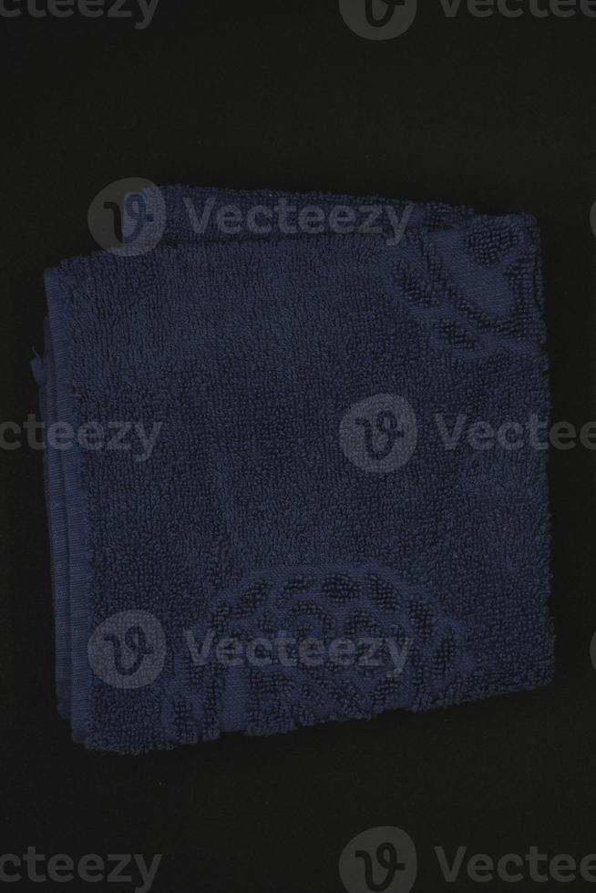 A cloth for wiping. Purple cloth on a black background. Towel. photo