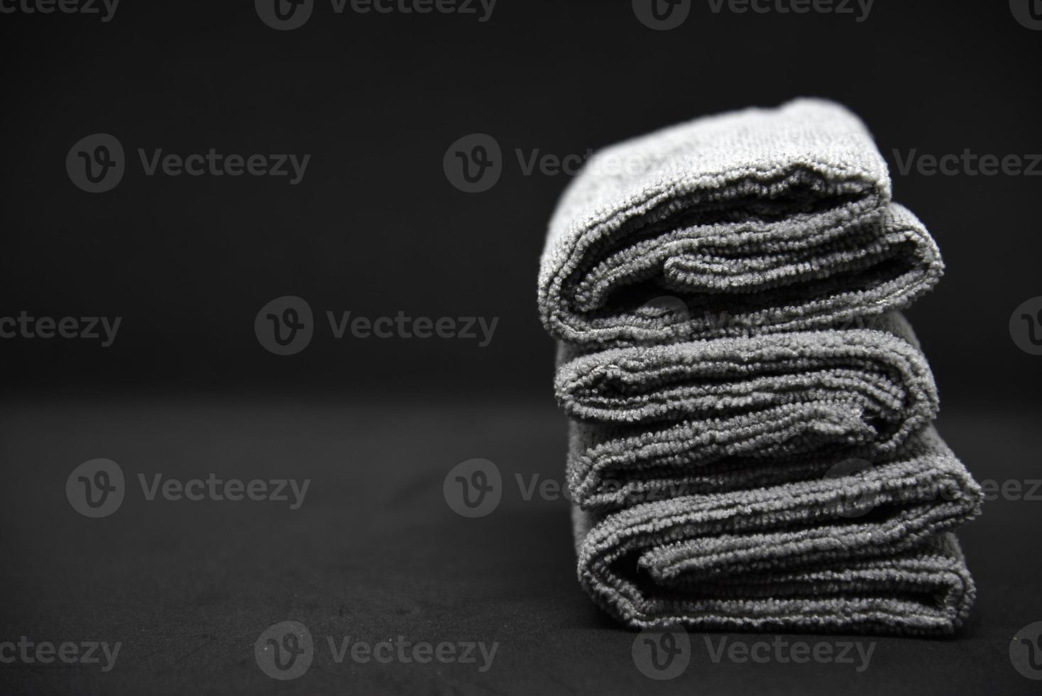 Three gray towels on a black background. Terry cloths for wiping furniture. Towels on a black background. photo