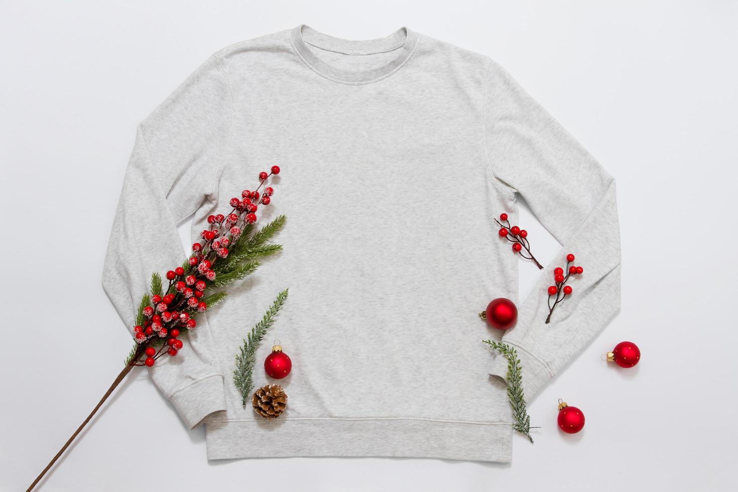 Close up blank template shirt, gray sweatshirt hoodie with copy space and Christmas Holiday concept. Top view mockup sweater isolated on white background. Happy New Year decorations. Xmas jamper photo