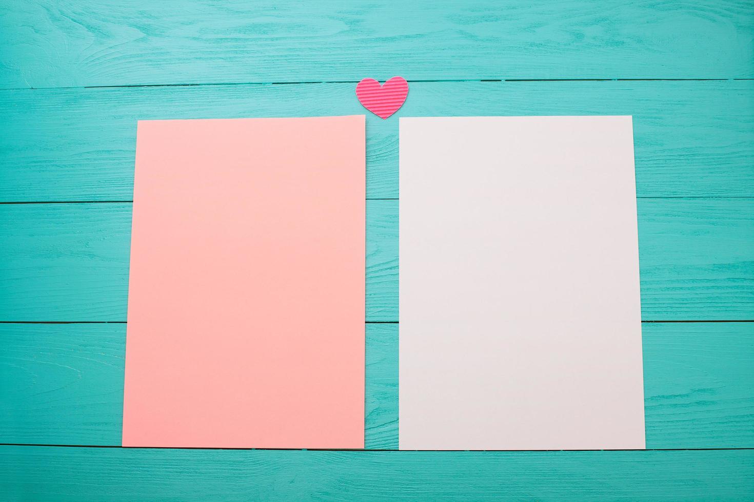 hojas de papel en blanco de color vacías sobre una mesa de madera de cerca foto