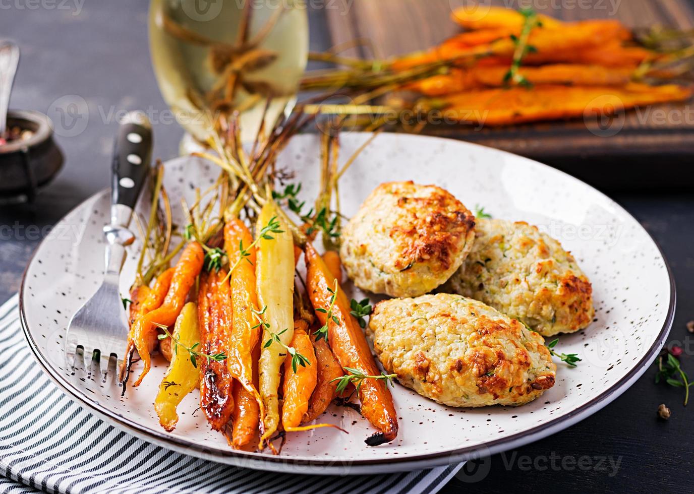 zanahorias orgánicas al horno con tomillo y chuleta, carne de pollo con albóndigas y calabacín. comida dietetica. foto