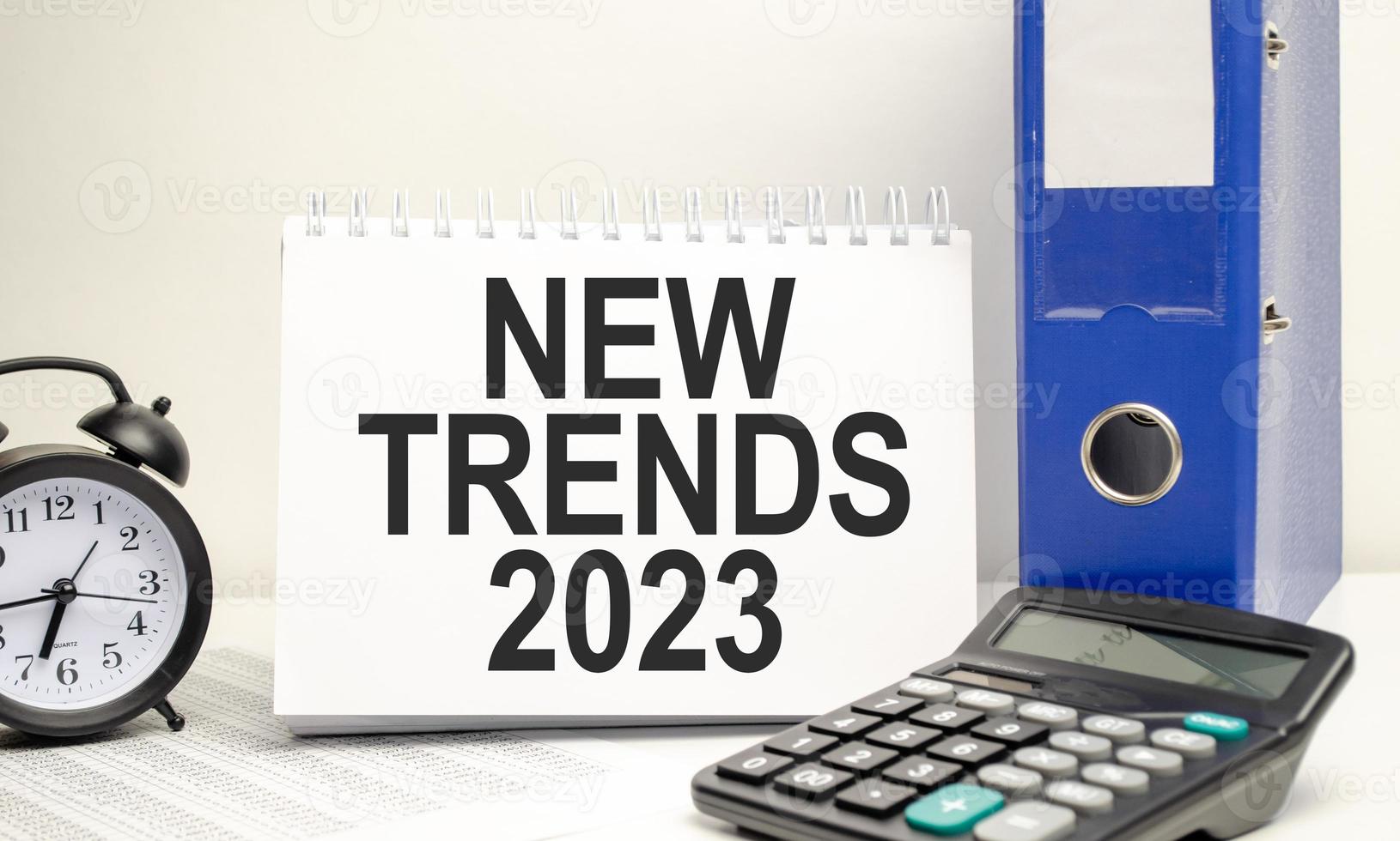 white notebook with the text TRENDS 2023 with calculator and paper folder photo