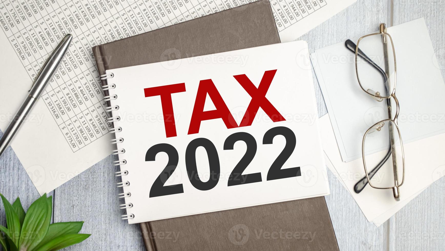 impuesto 2022, sistema tributario. palabra cuaderno blanco y papeles foto