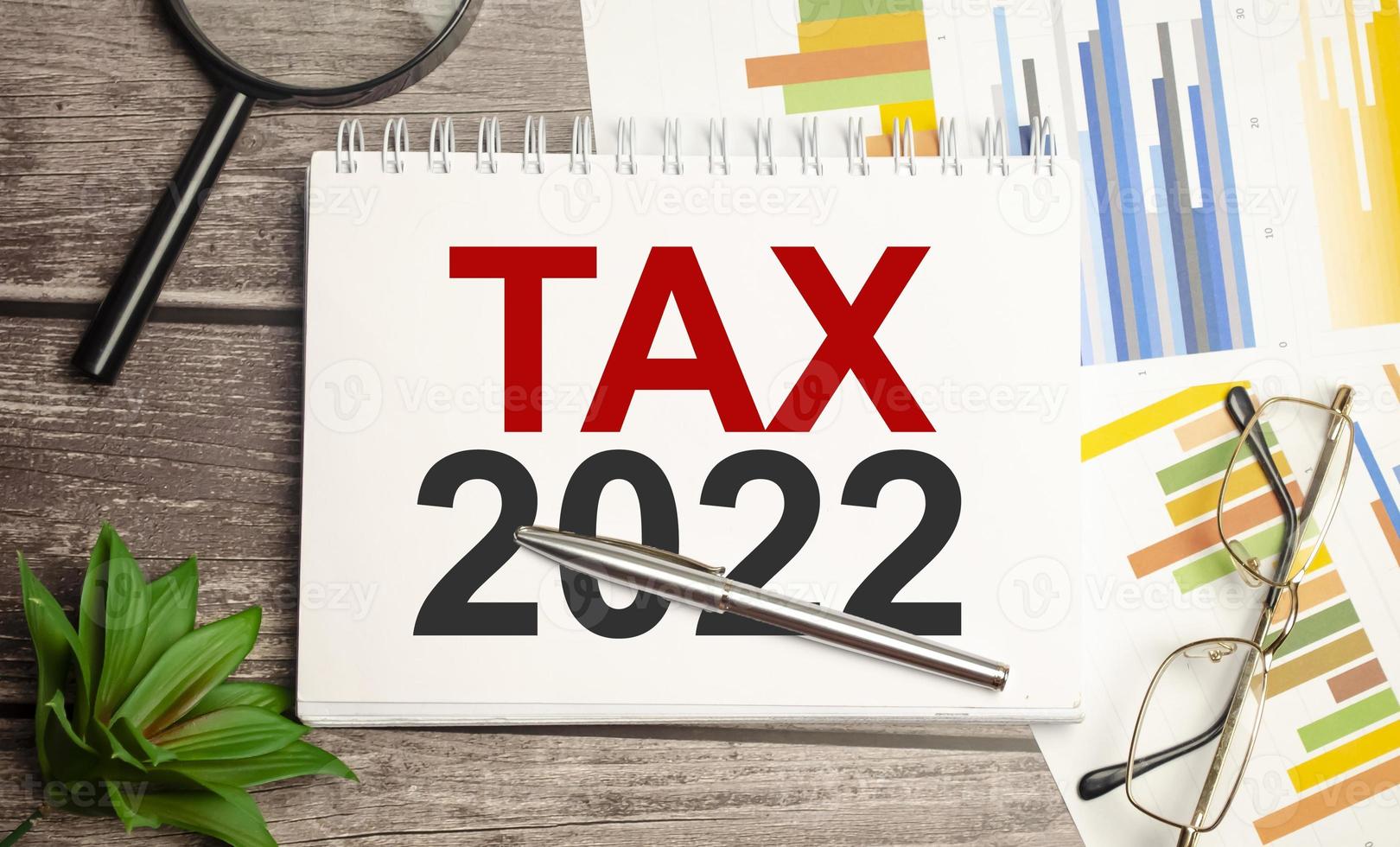 Tax 2022, taxation system. Word on white notebook and charts photo