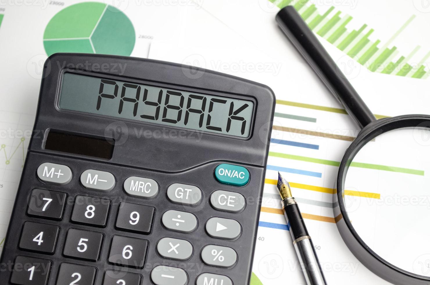 Word PAYBACK written on calculator on office table. photo