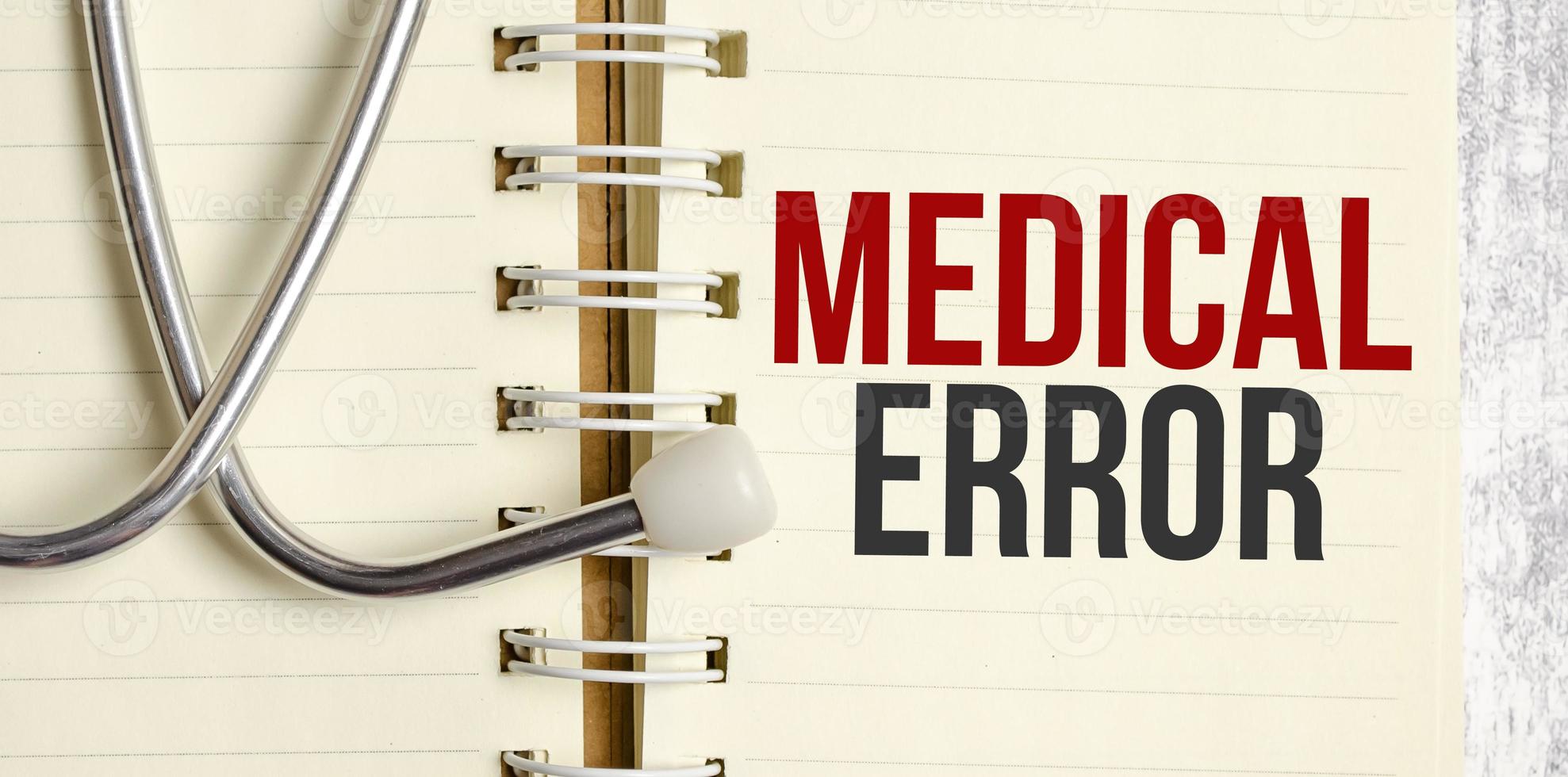 text MEDICAL ERROR words on a notebook on wooden table photo