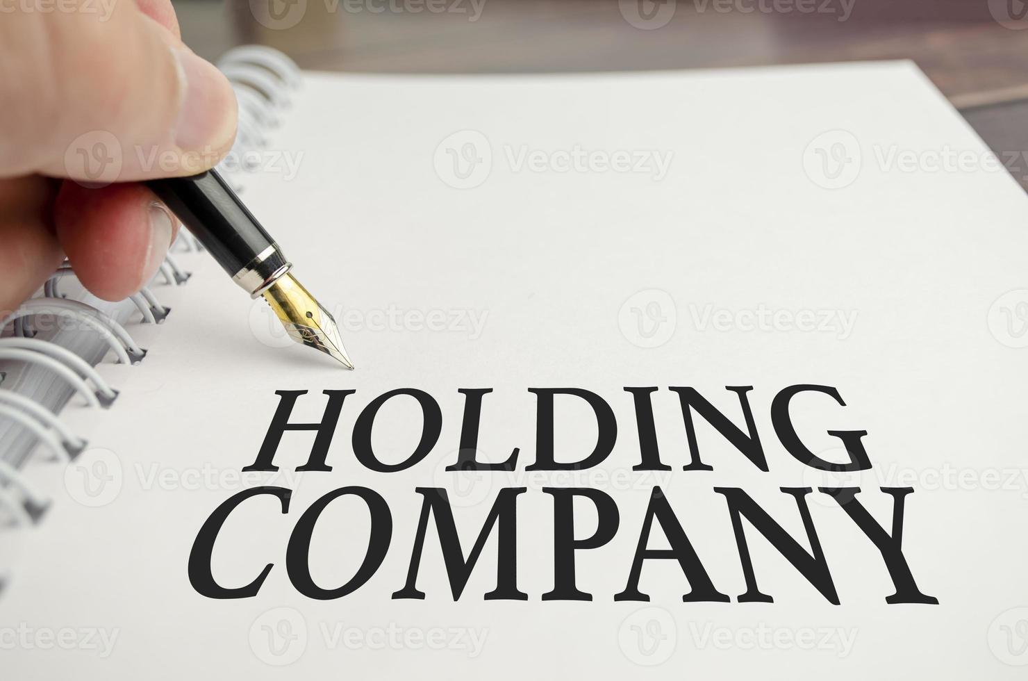 holding company words with pen on white background photo
