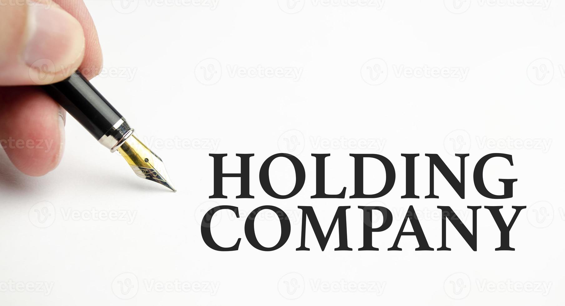 holding company words with pen on white background photo