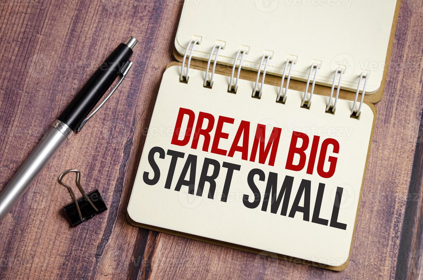 dream big start small words on notebook with pen and clips photo