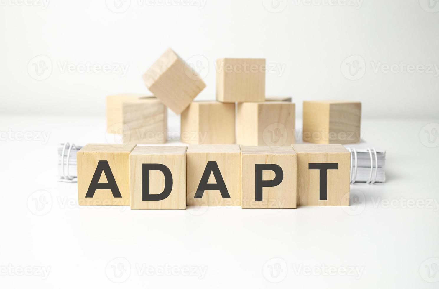 Adapt word cube on white background with notebooks photo