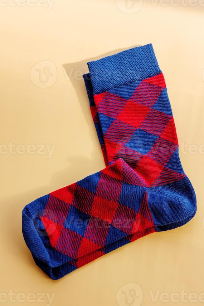 A pair of socks. Red and blue checkered socks on a beige background. photo