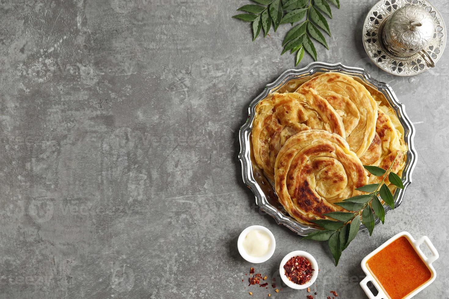 Roti Parata or Roti Canai with Lamb Curry Sauce and Yoghurt. photo