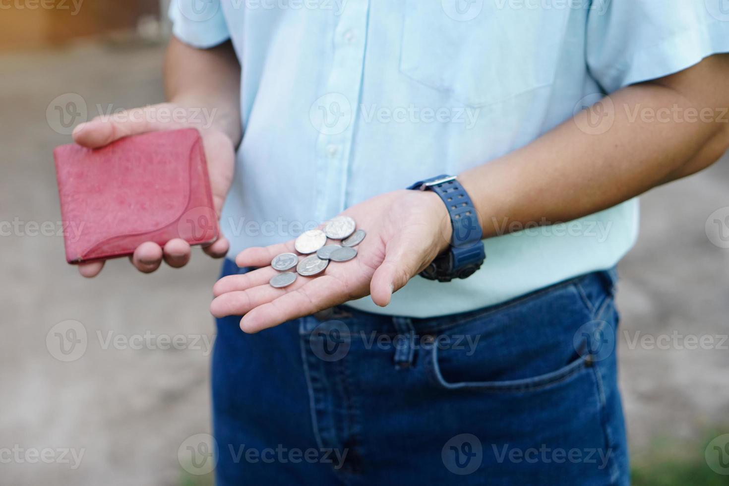 Closeup hand holds Thai baht coins and empty wallet.  Concept, no money, economic crisis. Financial problems. Broke or less money at the end of month. photo