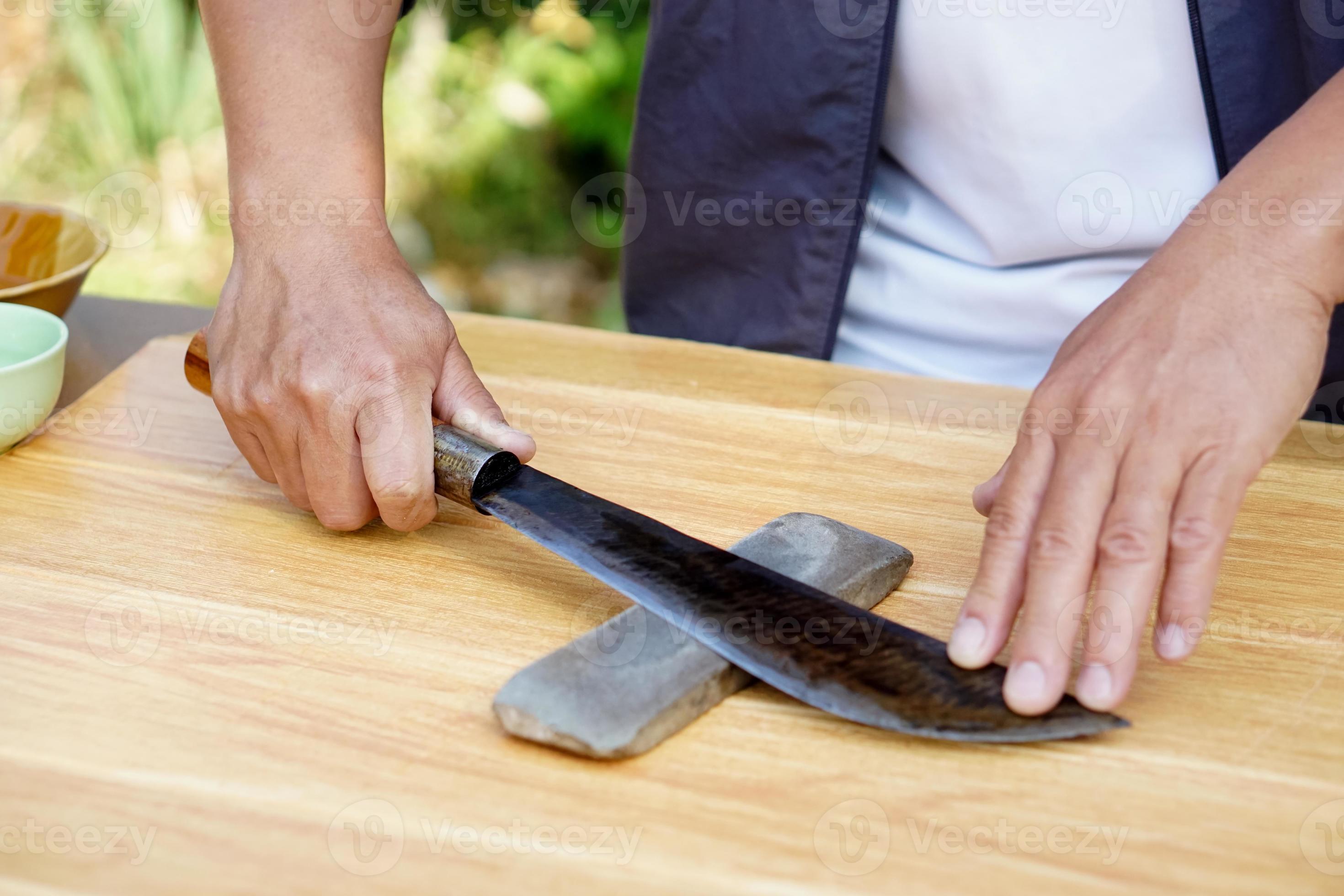 Premium Photo  The man using whetstone to sharpening his pocket knife  pocket knife care and maintenance concept