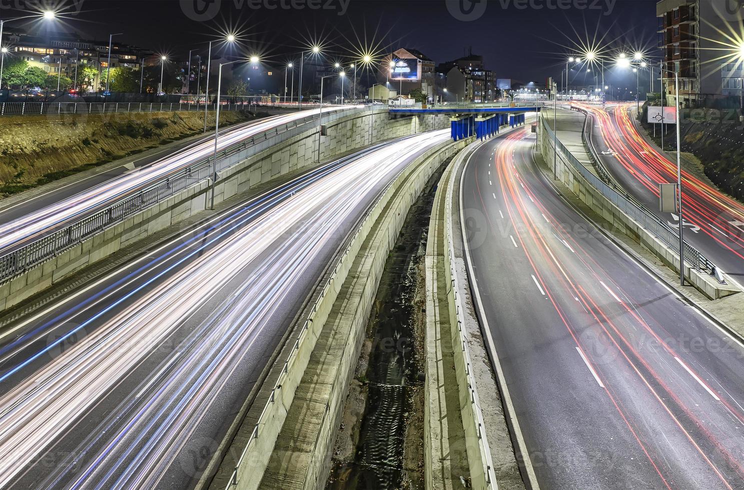 Stunning night traffic junction road with lights of vehicle movement. photo