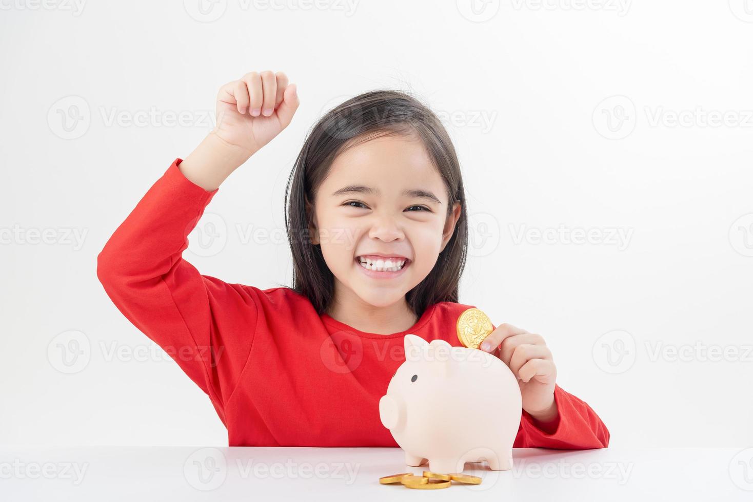 Little Asian girl saving money in a piggy bank, learning about saving, Kid save money for future education. Money, finances, insurance, and people concept photo