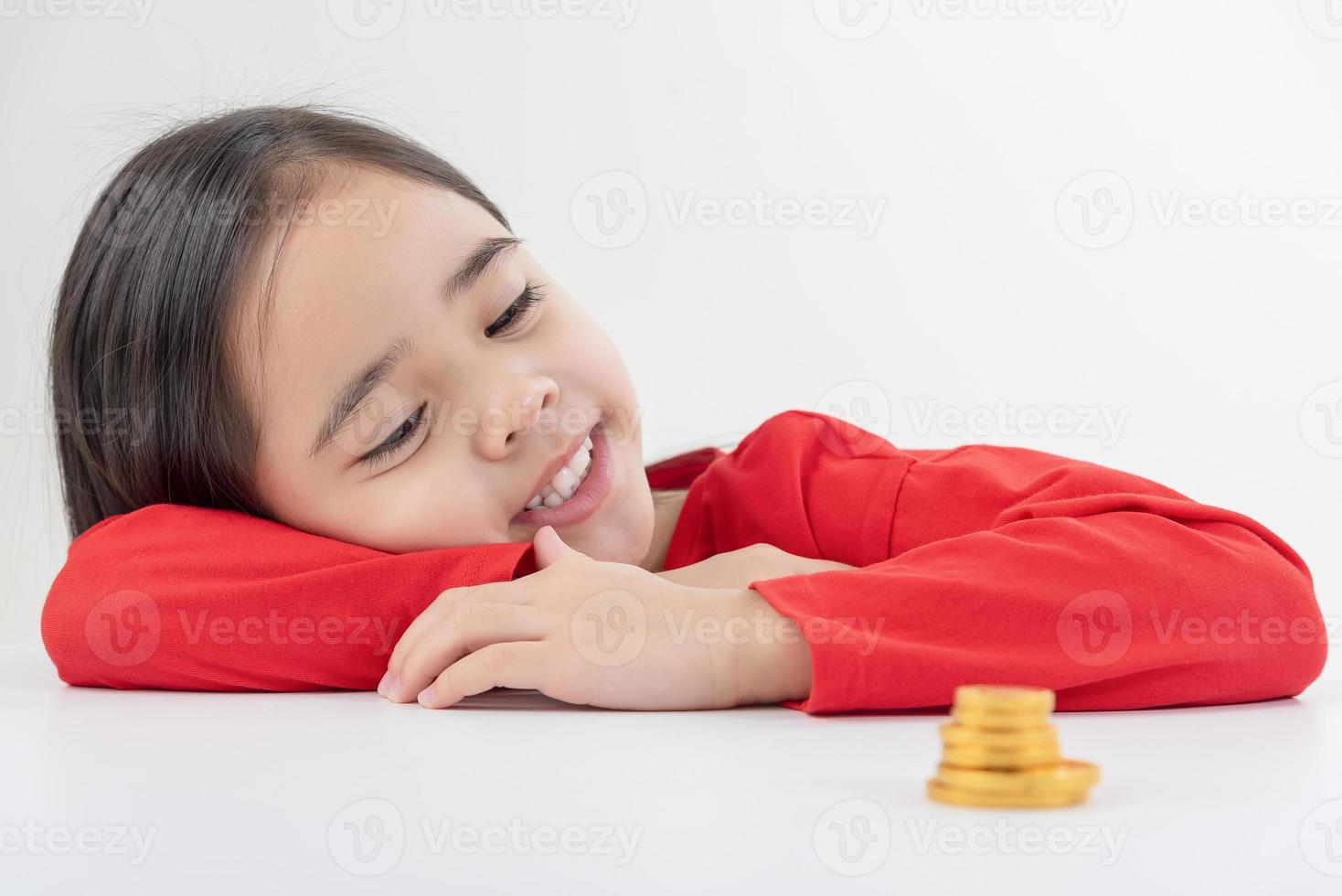 Little Asian girl saving money in a piggy bank, learning about saving, Kid save money for future education. Money, finances, insurance, and people concept photo