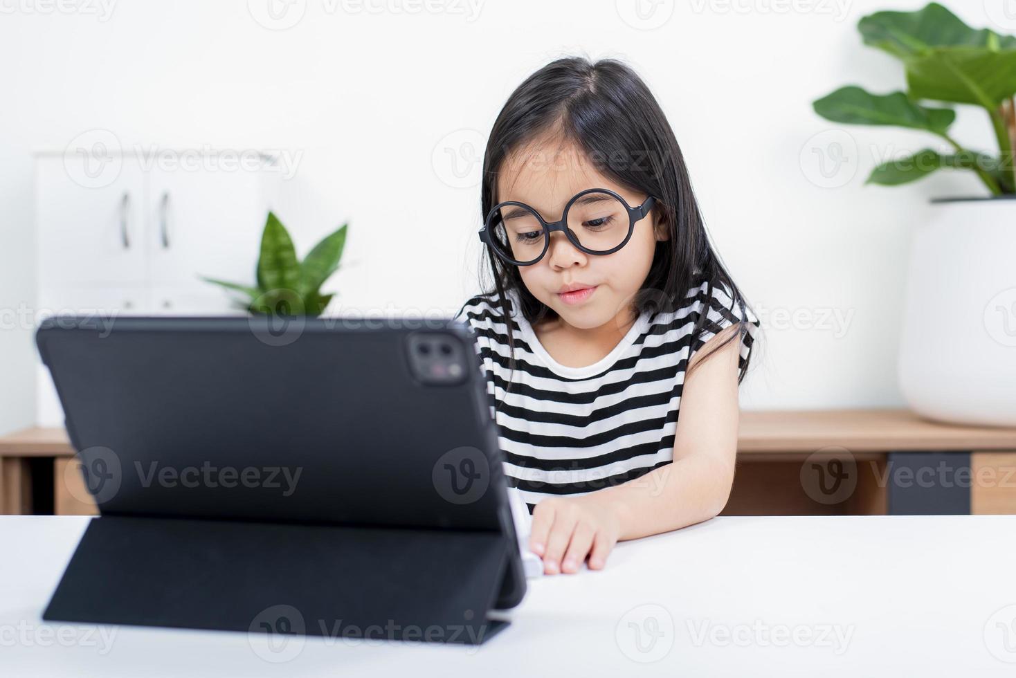 Asian child girl student wow excited on video call learning to studying online class or person learn from home school with tablet photo