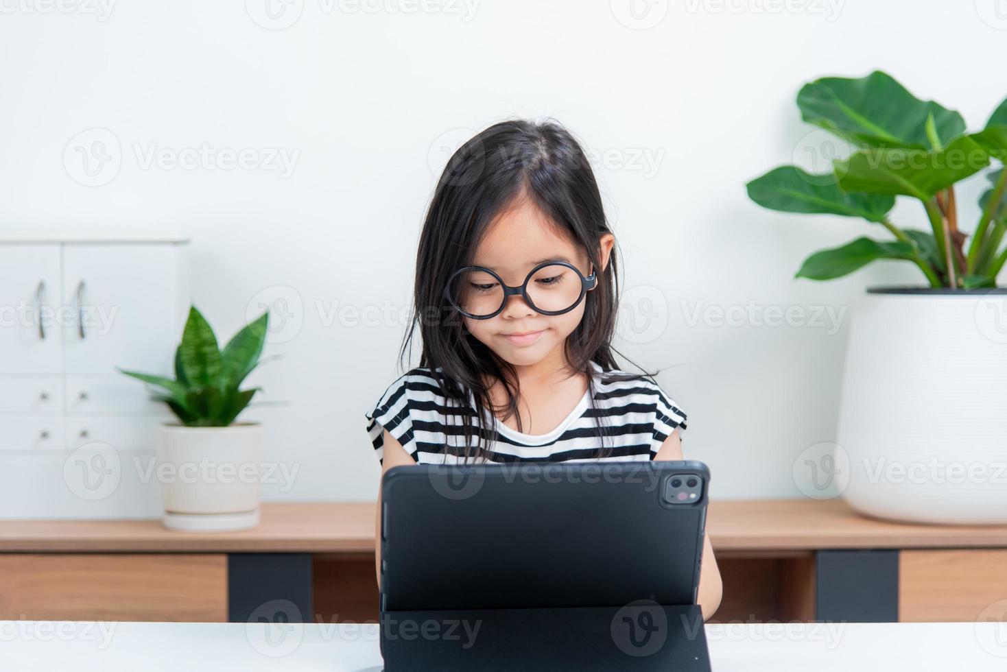 Asian child girl student wow excited on video call learning to studying online class or person learn from home school with tablet photo