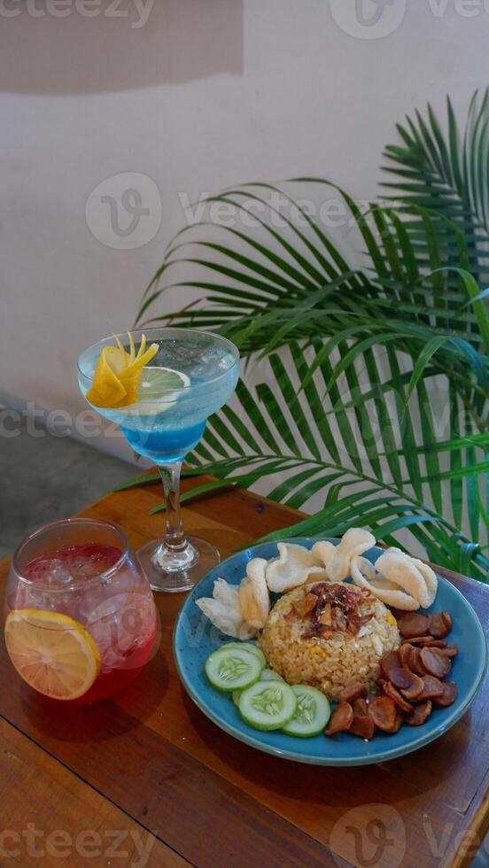 Nasi Goreng Jawa. The popular Indonesian rice dish of fried rice. cooked Javanese style with sweet soy sauce. Accompanied crackers, sausage, cucumber pieces, and soft drink. photo