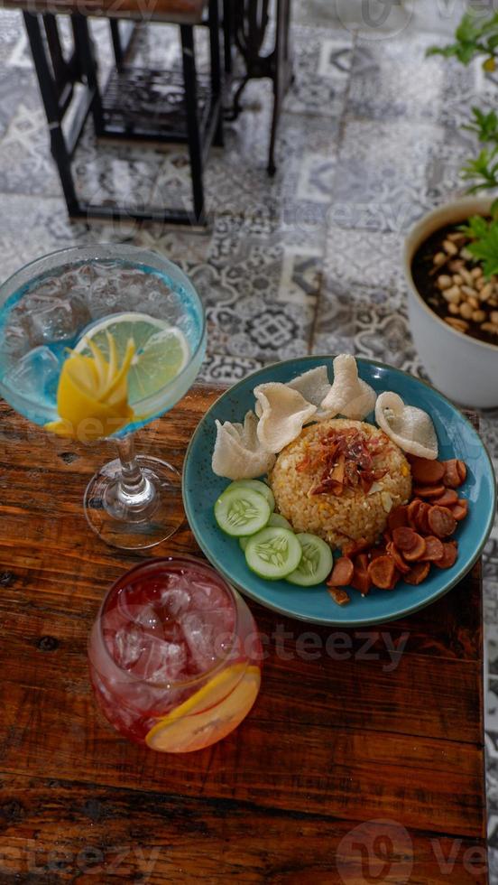 Nasi Goreng Jawa. The popular Indonesian rice dish of fried rice. cooked Javanese style with sweet soy sauce. Accompanied crackers, sausage, cucumber pieces, and soft drink. photo