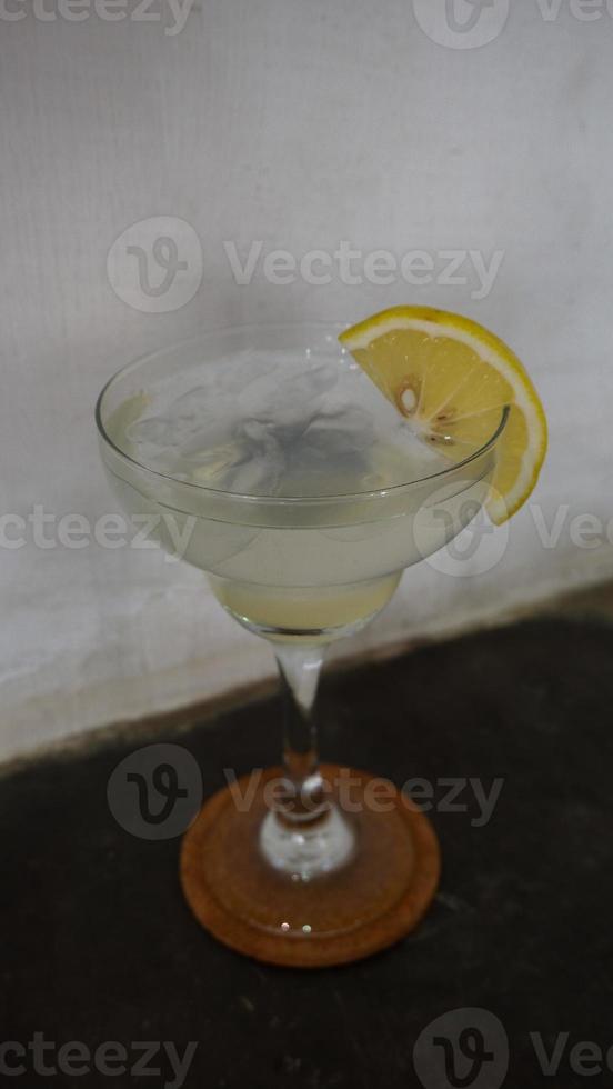 Lemonade. refreshing sparkling drink in an elegant glass garnished with a lemon wedge photo