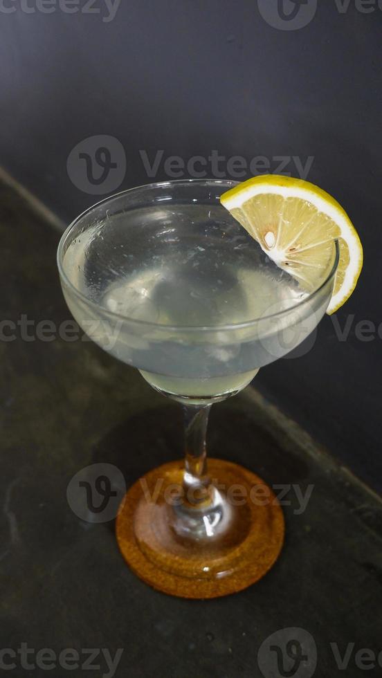 Lemonade. refreshing sparkling drink in an elegant glass garnished with a lemon wedge photo