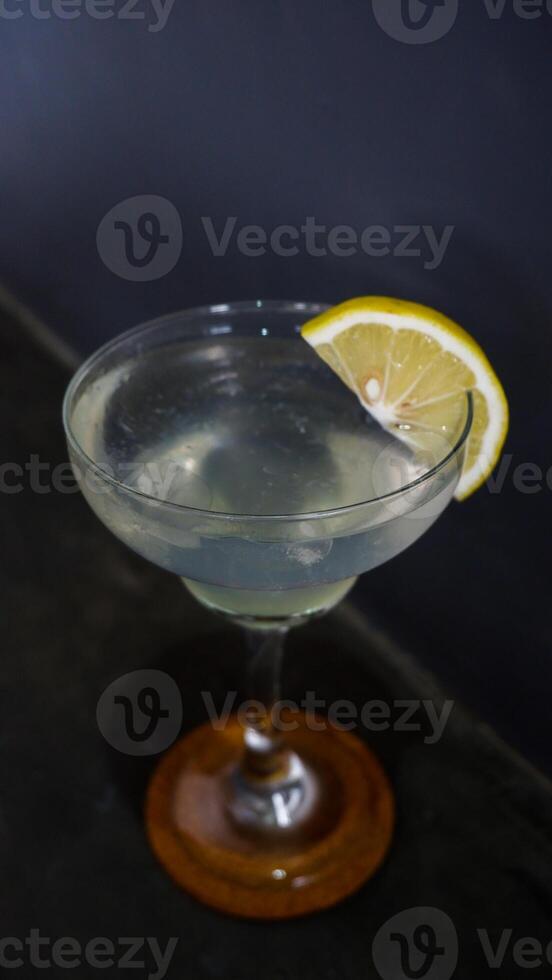 Lemonade. refreshing sparkling drink in an elegant glass garnished with a lemon wedge photo