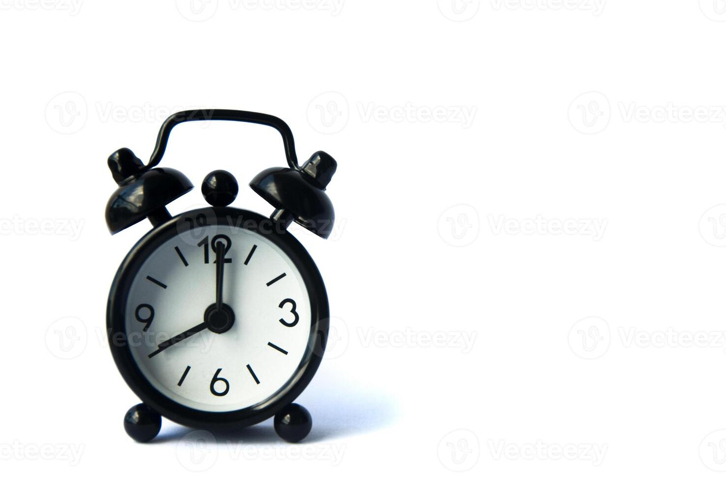 Black alarm clock isolated on white background. The clock set at 8 o'clock. photo