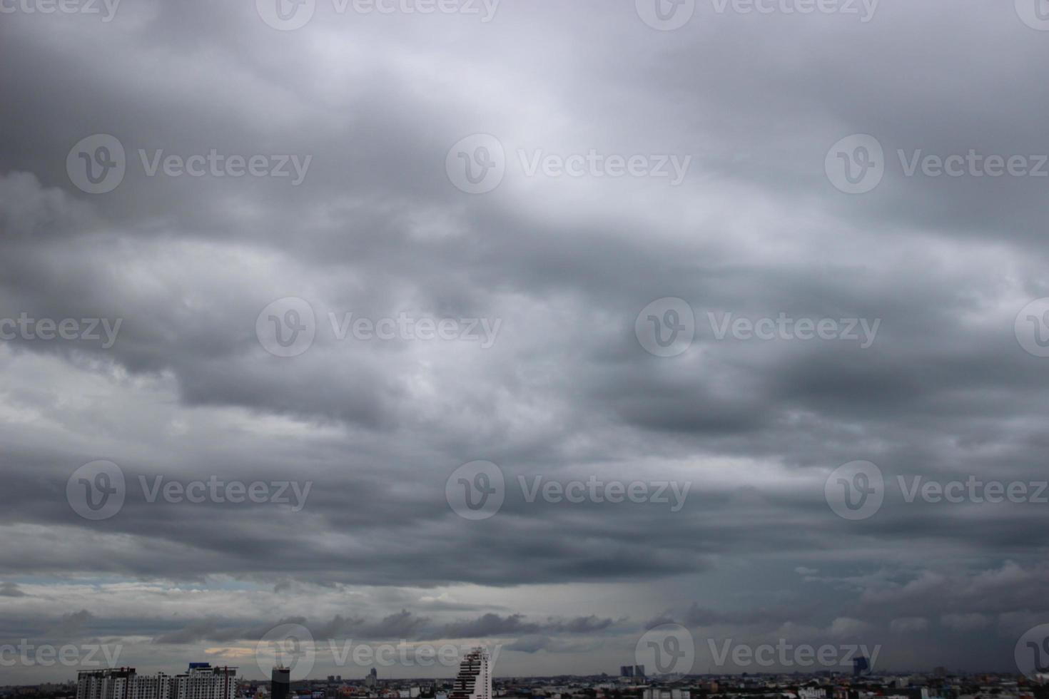 dark storm cloudy sky in rainy day with city building background photo