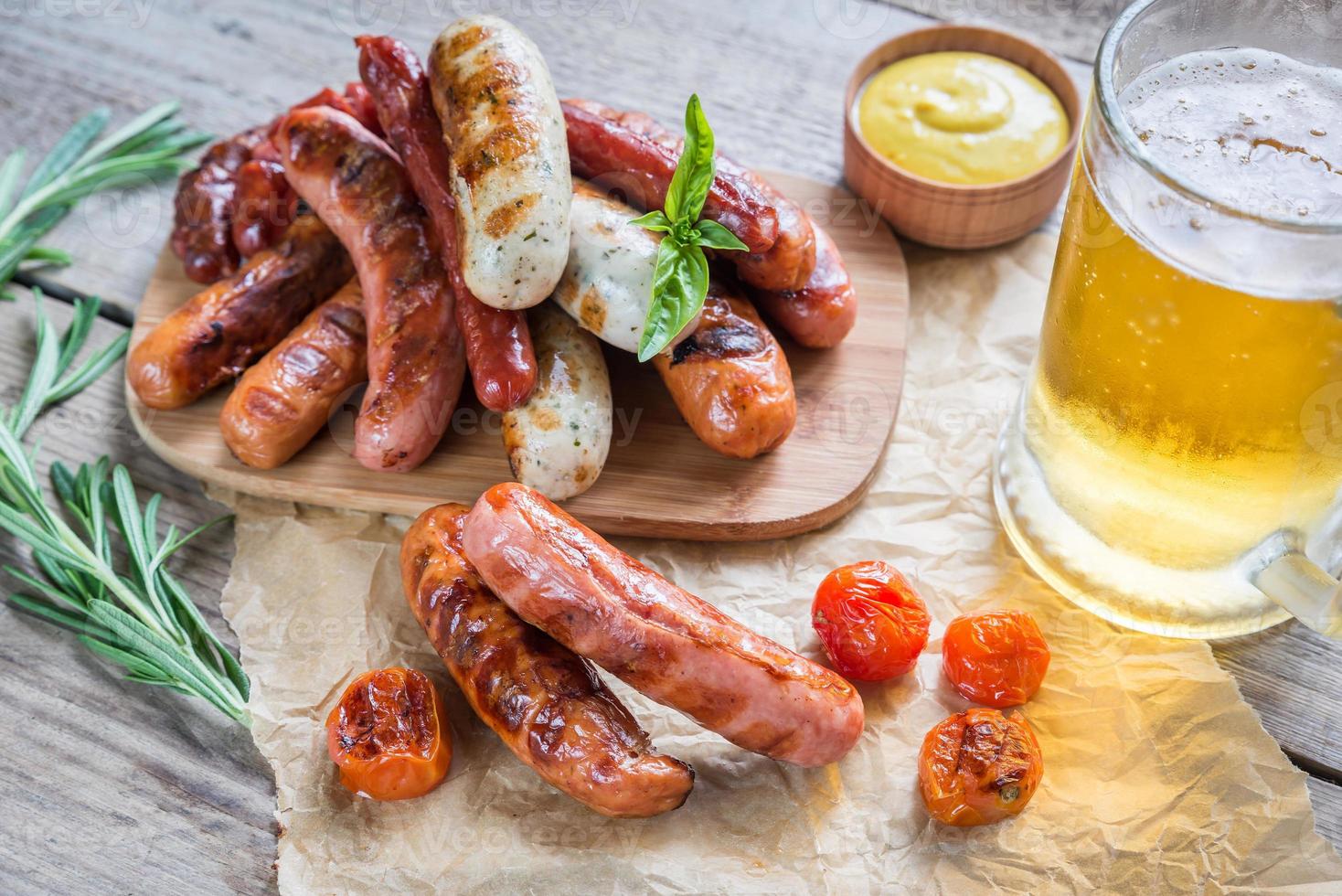 salchichas a la parrilla con un vaso de cerveza foto