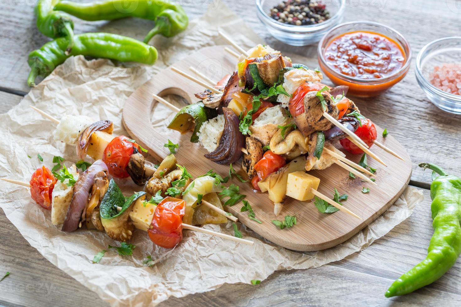 brochetas de verduras a la parrilla en la tabla de madera foto