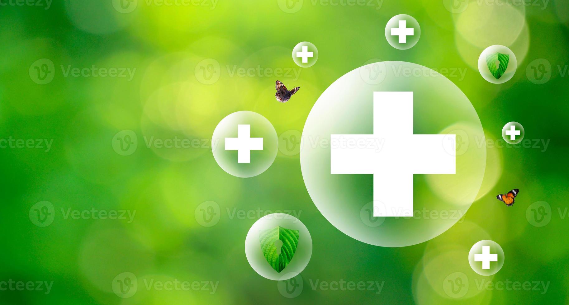 Plus symbol in balloon bubbles on natural green background. photo