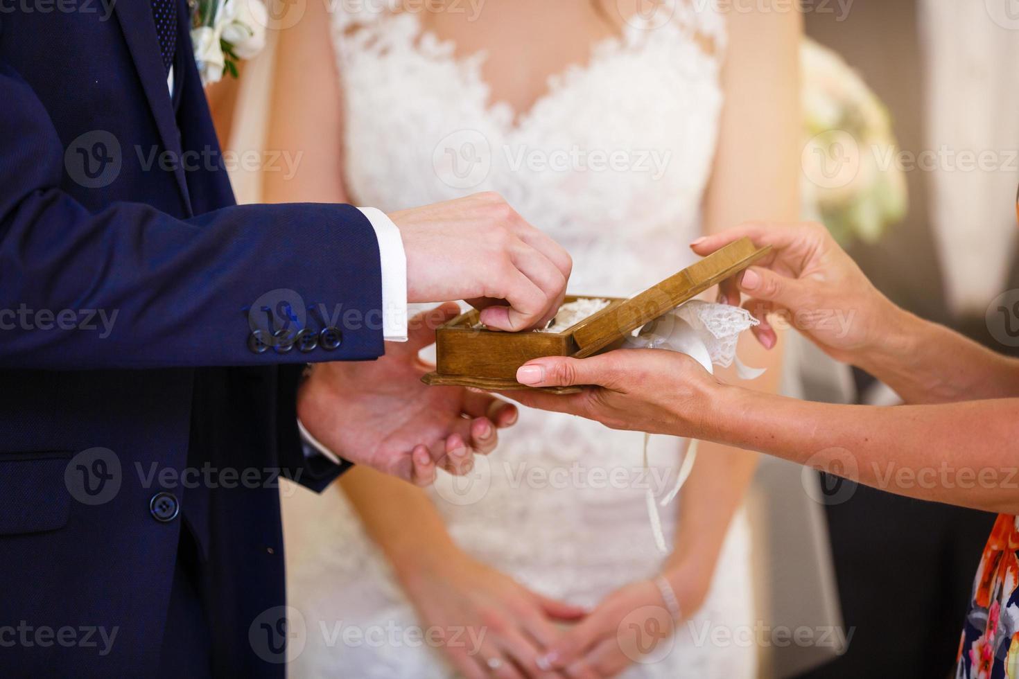 la novia y el novio intercambian anillos en la boda, primer plano, manos, dedos foto