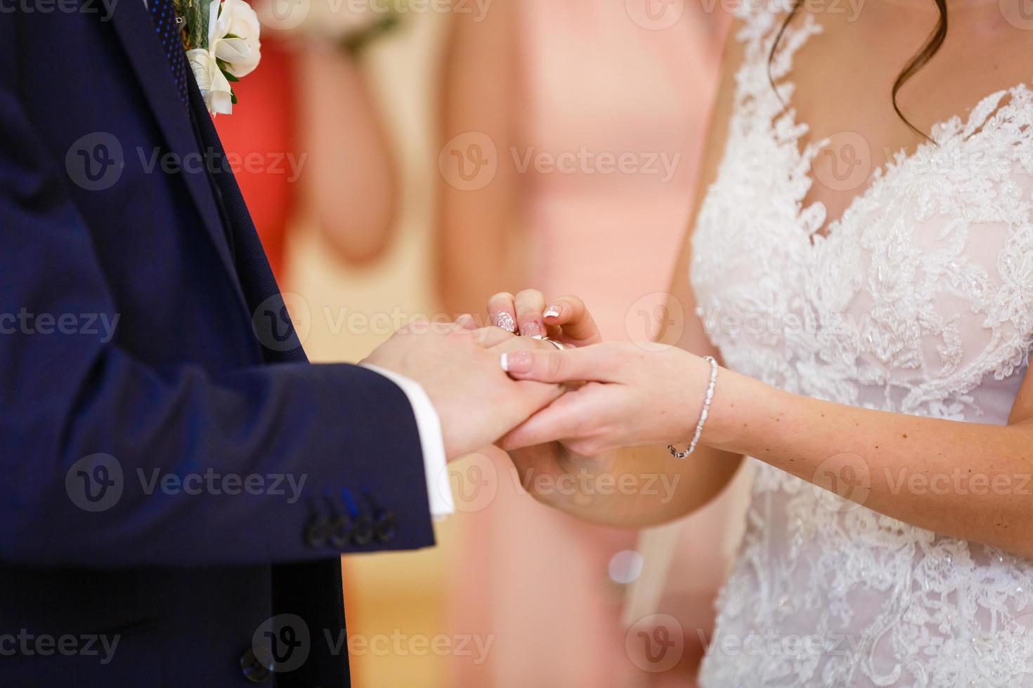 The bride and groom exchange rings at the wedding, closeup, hands, fingers photo